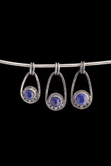Three Lapis Lazuli Cosmic Ray pendants in polished 925 sterling silver, shown on black with deep blue stones and celestial ray details.