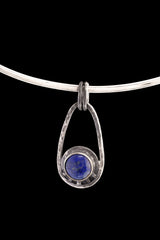 Single Lapis Lazuli Cosmic Ray pendant on black background with polished sterling silver frame and twin oval bail.