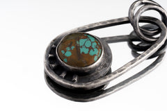 Close-up of Royston Turquoise cabochon with blue-green colour and earthy matrix in an oxidized sterling silver Cosmic Ray pendant.