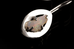 Close-up of Australian White Opal earring showing polished sterling silver halo setting and natural play of colour.