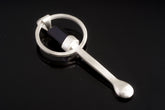 Black Tourmaline sterling silver hammered spoon pendant shown on dark background with sculptural silver form.