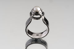 A Grade Basra Pearl Ring shown from the front with crest-like sterling silver setting and natural pearl focal stone.