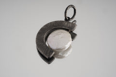Pearl crescent pendant in oxidized 925 sterling silver shown on a dark background with rugged crisscross texture.