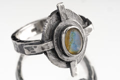 Rainbow Labradorite Compass Ring shown on white background with oxidized sterling silver setting and blue-green gemstone flash.
