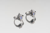 Oxidized Blue Moonstone Compass Ring shown on white background with hammered sterling silver face and oval Moonstone centre.