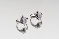 Oxidized Blue Moonstone Compass Ring shown on white background with hammered sterling silver face and oval Moonstone centre.