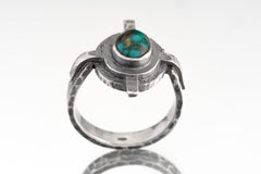 Himalayan Turquoise Compass Ring shown from the front with circular textured silver frame and blue-green stone.