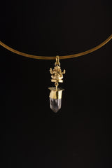 Meditating Ganesha Clear Quartz pendant shown worn on a black background as a lightweight golden brass spiritual charm.