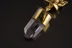 Ganesha Clear Quartz talisman pendant shown on black background with shiny brass finish and Himalayan Quartz crystal.