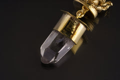 Ganesha Clear Quartz talisman pendant shown on black background with shiny brass finish and Himalayan Quartz crystal.