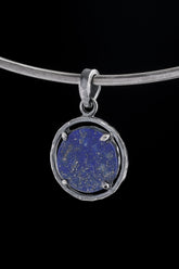 Brazilian Lapis Lazuli oval pendant in oxidized 925 sterling silver, shown on black with golden Pyrite flecks and hammered frame.