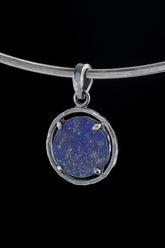 Brazilian Lapis Lazuli oval pendant in oxidized 925 sterling silver, shown on black with golden Pyrite flecks and hammered frame.