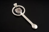 Clear Quartz sterling silver hammered spoon pendant shown on dark background with sculptural silver form and clear stone.