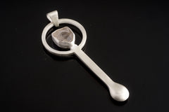 Clear Quartz sterling silver hammered spoon pendant shown on dark background with sculptural silver form and clear stone.