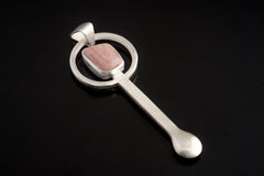 Rhodochrosite sterling silver hammered spoon pendant shown on dark background with pink stone and sculptural spoon form.