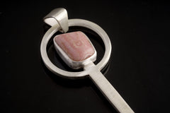 Close-up of Rhodochrosite spoon pendant showing hammered sterling silver texture and square pink stone setting.