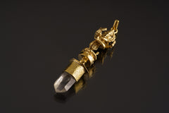 Dancing Ganesha Clear Quartz pendant shown on a dark background with warm brass setting and clear crystal point.