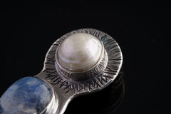 Close-up of South Sea Pearl and Blue Moonstone Venus pendant showing textured sterling silver detail.