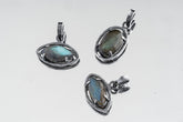 Collection of oxidized 925 sterling silver Madagascan Labradorite claw pendants with shifting blue-green flash on a light background.
