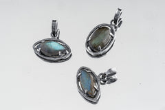 Collection of oxidized 925 sterling silver Madagascan Labradorite claw pendants with shifting blue-green flash on a light background.
