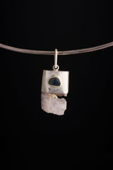 Pink Kunzite Sapphire pendant shown worn on a black necklace, with raw crystal wand shape and brushed silver cap setting.