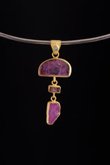 Rubellite, Black Opal, Pink Tourmaline, and Ruby pendant shown worn on a black cord, with long gold-plated vertical design.