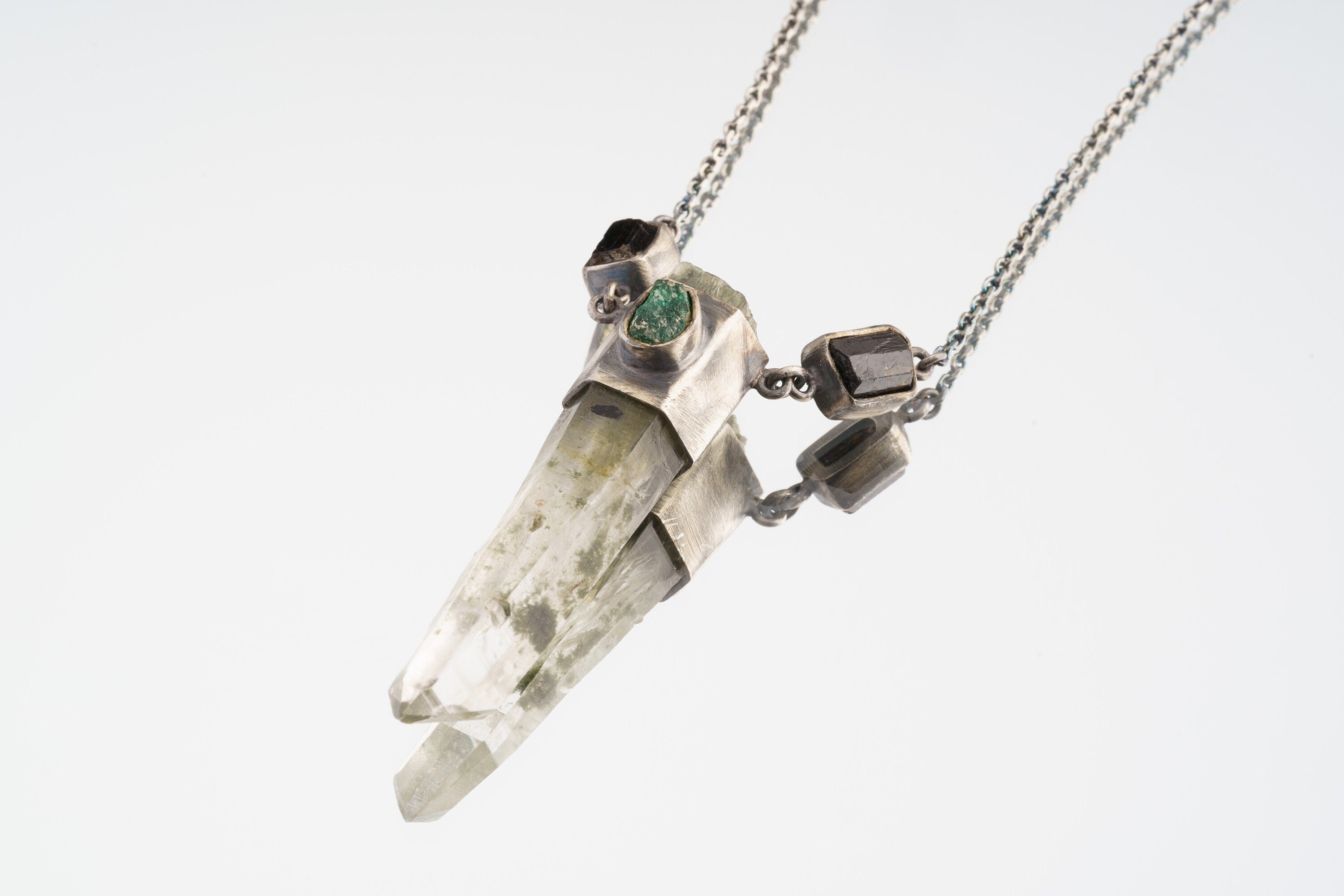 Verdant Quartz Relic Necklace shown on light background with front-set Emerald, raw Quartz point, and silver wrap setting.
