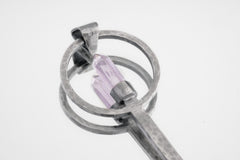 Close-up of Amethyst Generator spoon showing brushed sterling silver texture and pointed purple crystal setting.