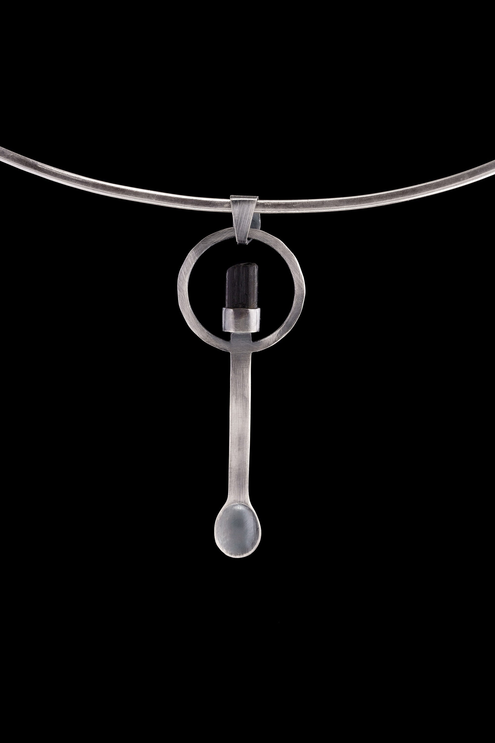 Black Tourmaline spoon pendant shown on a silver choker with solid 925 sterling silver and dark crystal detail.