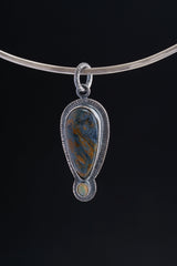 Pietersite Ethiopian Opal pendant displayed on a choker against black background with sterling silver setting.