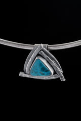 Chrysocolla triangle pendant displayed on a choker with concealed tube bail and oxidized silver setting.