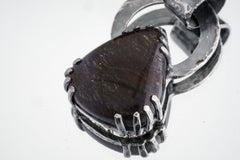 Teardrop Amethyst held in heavy brutalist sterling silver claw setting.