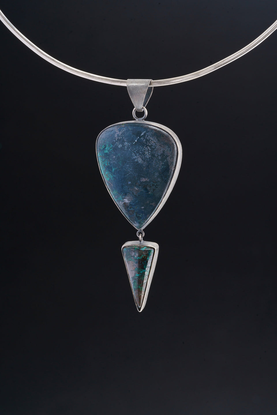 Malachite Chrysocolla statement pendant displayed on a choker against dark background with silver setting.