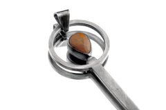 Fiery Ethiopian Opal spoon pendant shown close-up with solid 925 sterling silver and teardrop Opal setting.