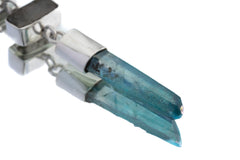 Black Rutile Quartz Aqua Aura pendant shown on white background with blue crystal point and silver setting.