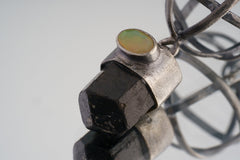 Close-up of Himalayan Brown Tourmaline point with Ethiopian Opal set into the oxidized sterling silver cap.