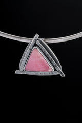 Rhodochrosite triangle pendant displayed on a choker against black background with concealed tubular bail.