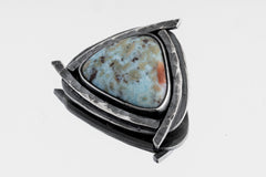 Azure Triad Larimar pendant shown on white background with blue ocean stone and oxidized silver triangle frame.