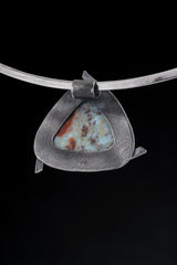 Larimar pendant shown from the back with open-back sterling silver triangle construction.