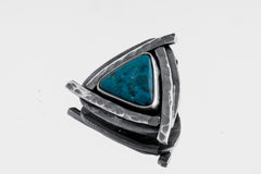 Serene Triad Chrysocolla pendant shown on white background with blue-green stone and oxidized silver triangle frame.