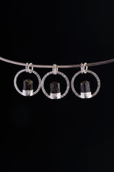 Himalayan Tourmaline halo pendant displayed on silver choker against black background.