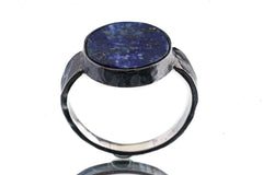 Large circular Lapis Lazuli ring shown from the front, with deep blue stone and rugged hammered silver texture.