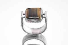 Front view of rectangular Tiger Eye ring showing U-shaped oxidized silver band and sculptural bezel setting.