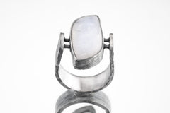 Front view of rectangular Moonstone ring showing U-shaped oxidized silver band and sculptural lunar setting.