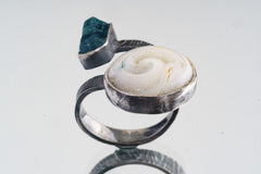Land and Sea Apatite Shell ring shown on a white background, with blue terminated crystal and fossilized shell setting.