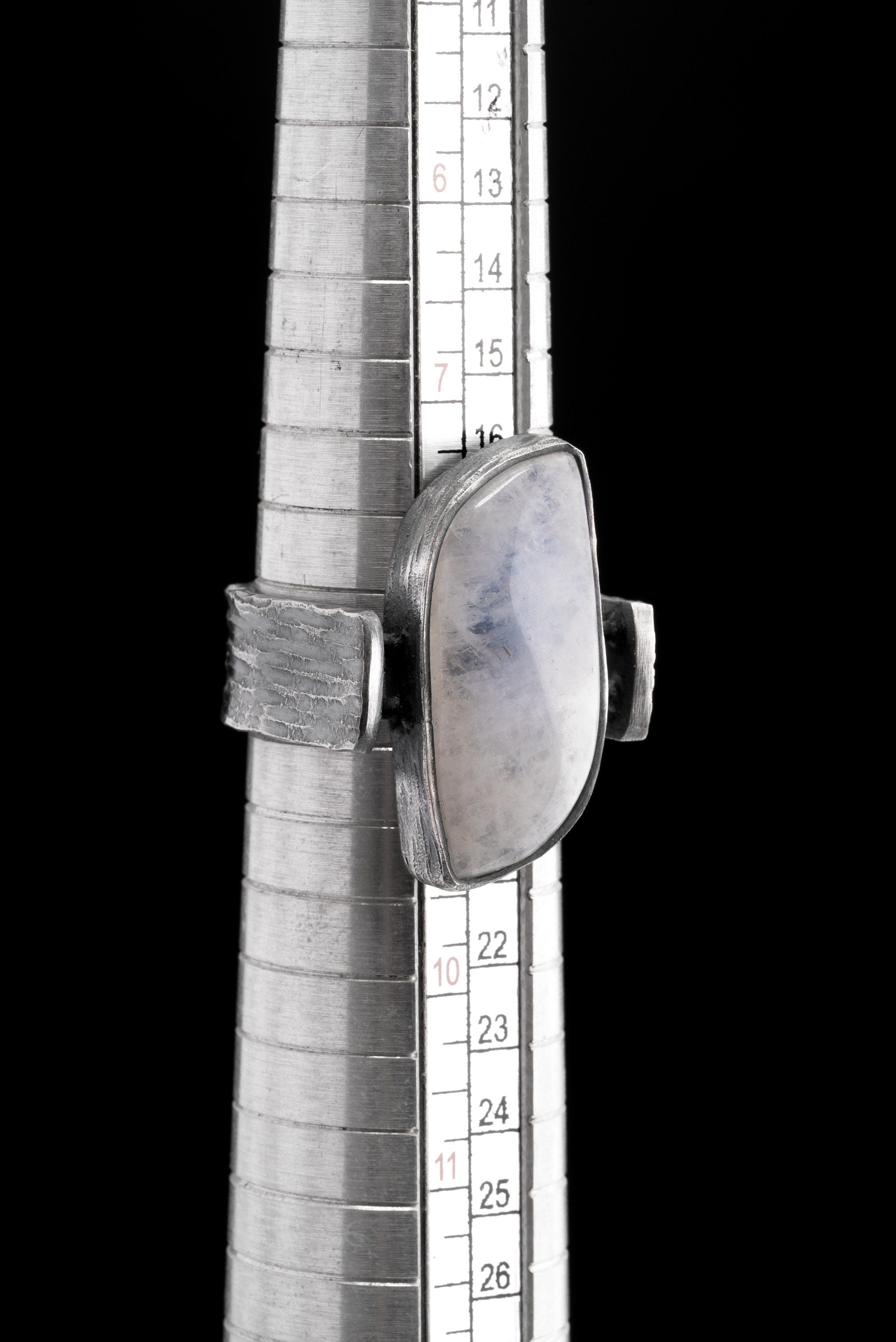 Rectangular Moonstone ring shown beside a ruler for scale, with oxidized 925 sterling silver and brutalist band profile.