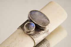 Close-up of antique bone tube pendant showing 925 sterling silver band with oval and round Blue Moonstone settings.