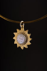 Gold-plated brass sun and Mother of Pearl pendant shown on a dark background, with carved celestial shape and round centre.