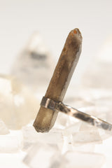 Raw Smoky Citrine Quartz ring displayed with clear Quartz crystals on pale background.