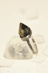 Raw green Dioptase ring displayed with quartz crystals on pale background.